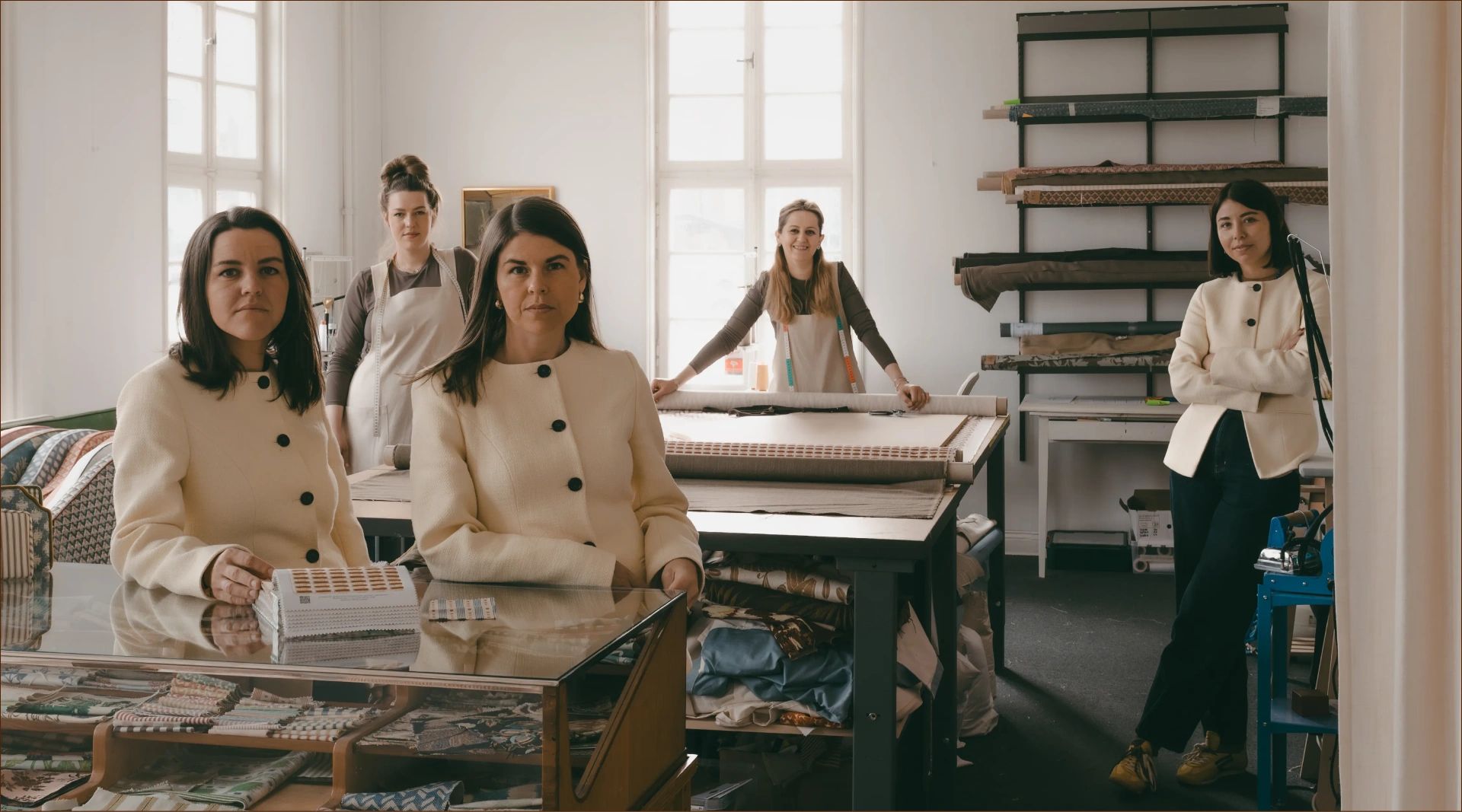 The YLSE atelier — founders and craftspeople surrounded by fabrics, samples and upholstery work in progress.